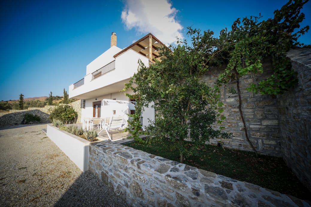 a white house with a stone wall