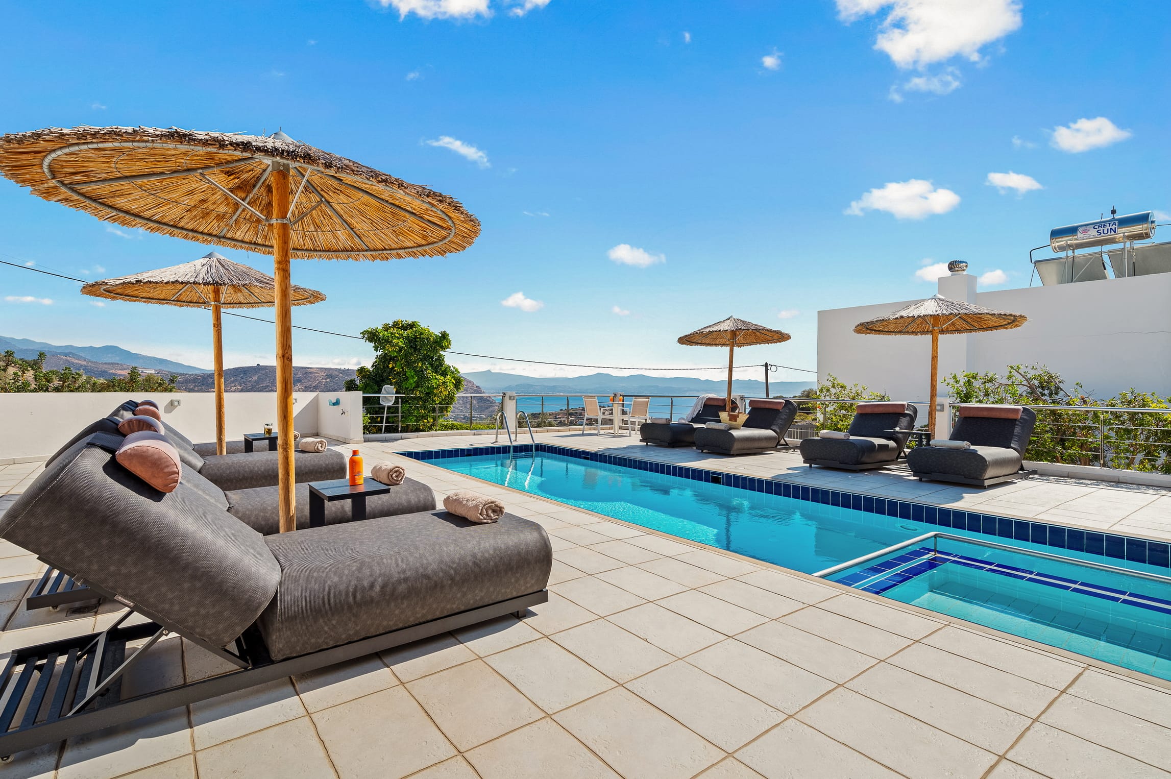 a pool with lounge chairs and umbrellas next to it