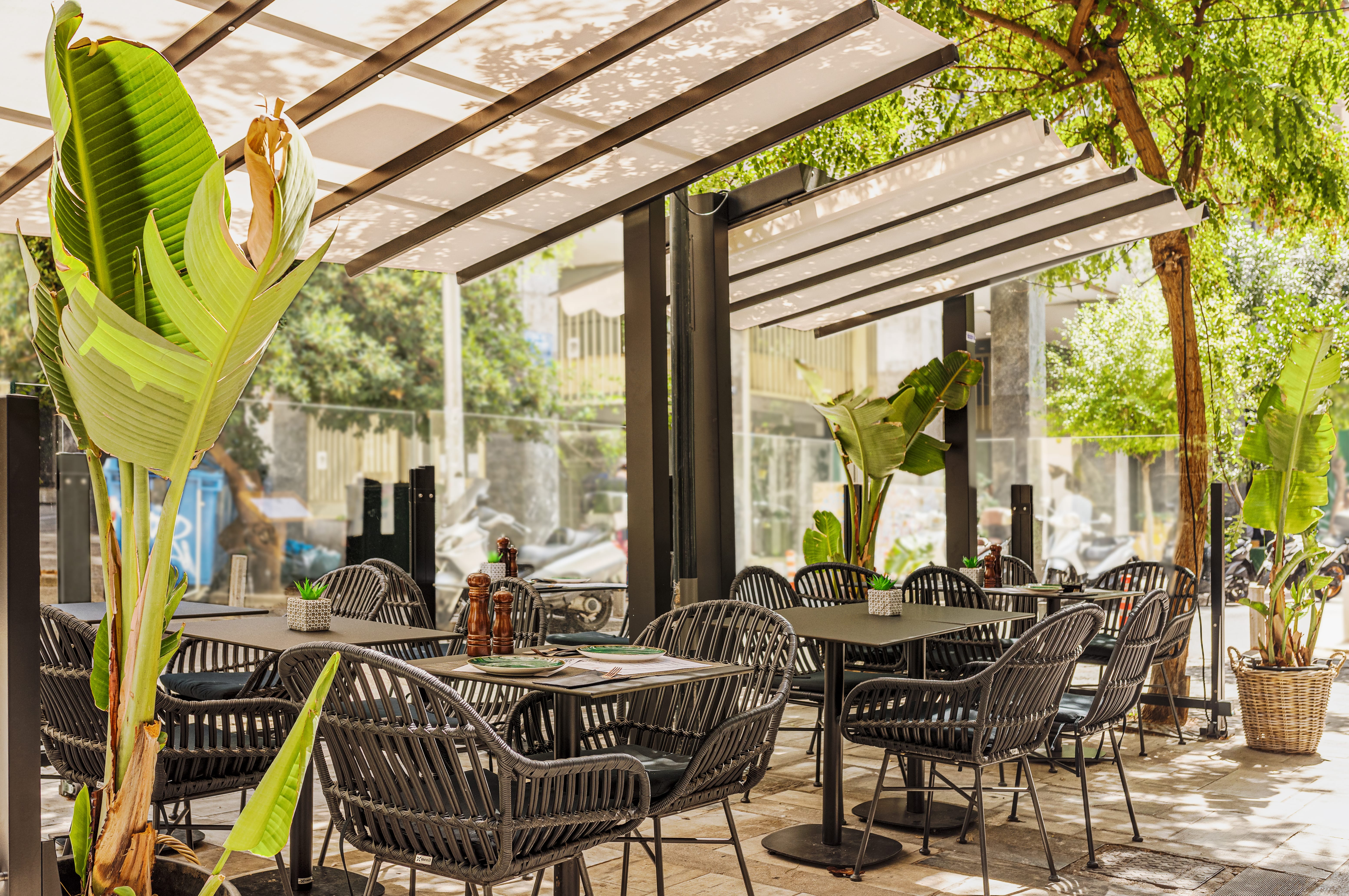 a group of tables and chairs under a covered area