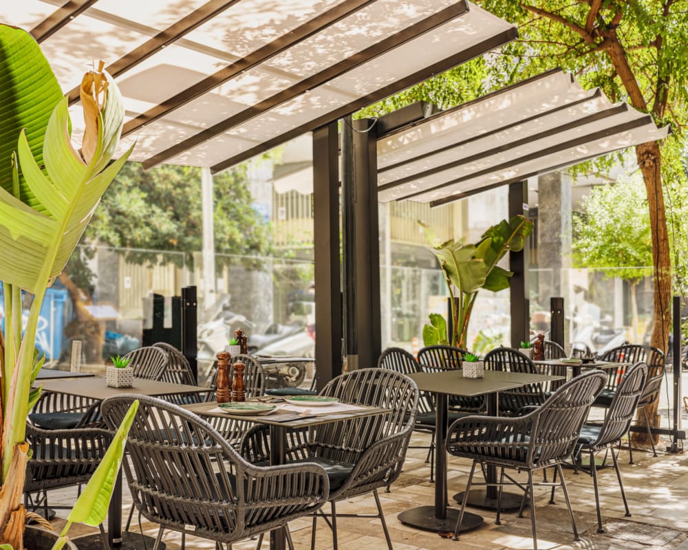 a group of tables and chairs under a covered area