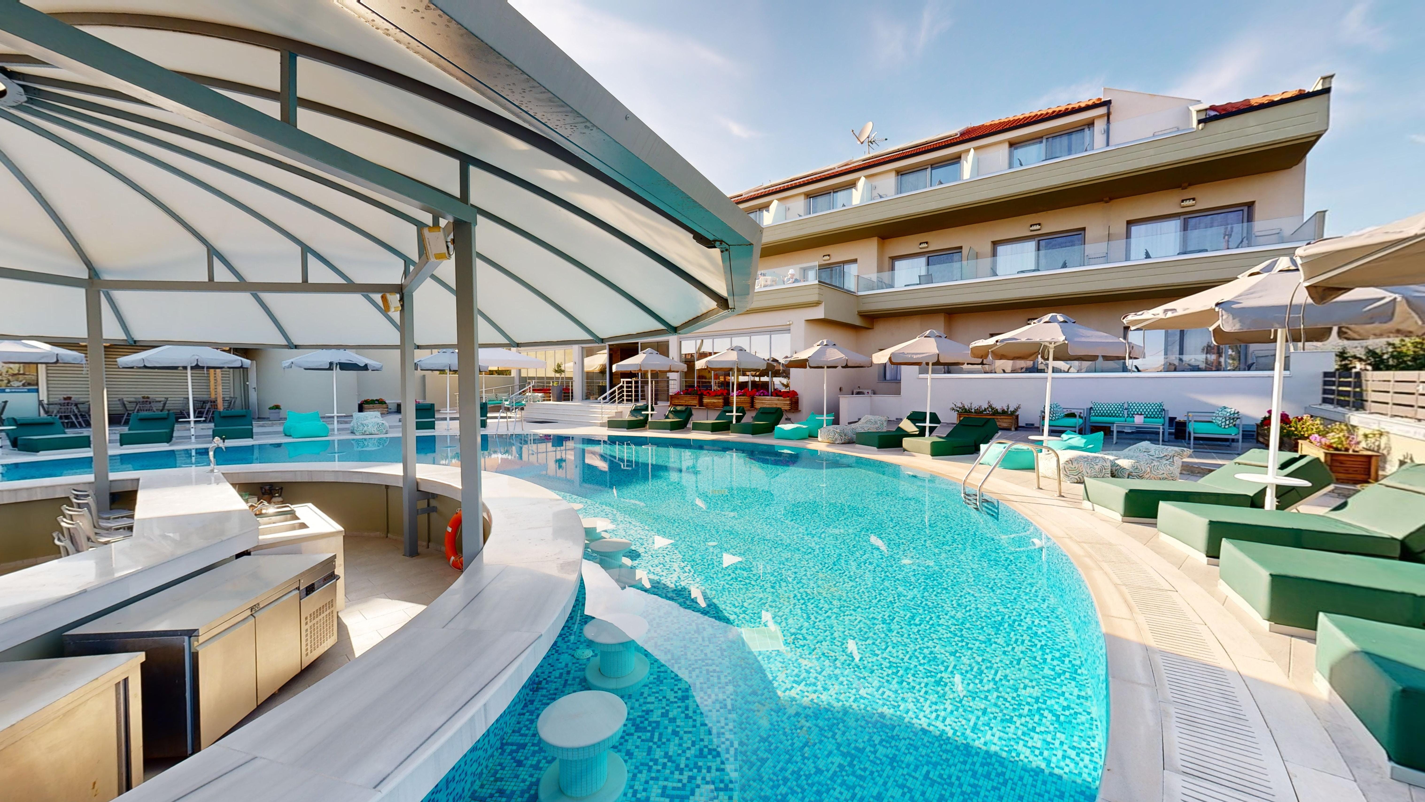 a swimming pool with lounge chairs and umbrellas next to it