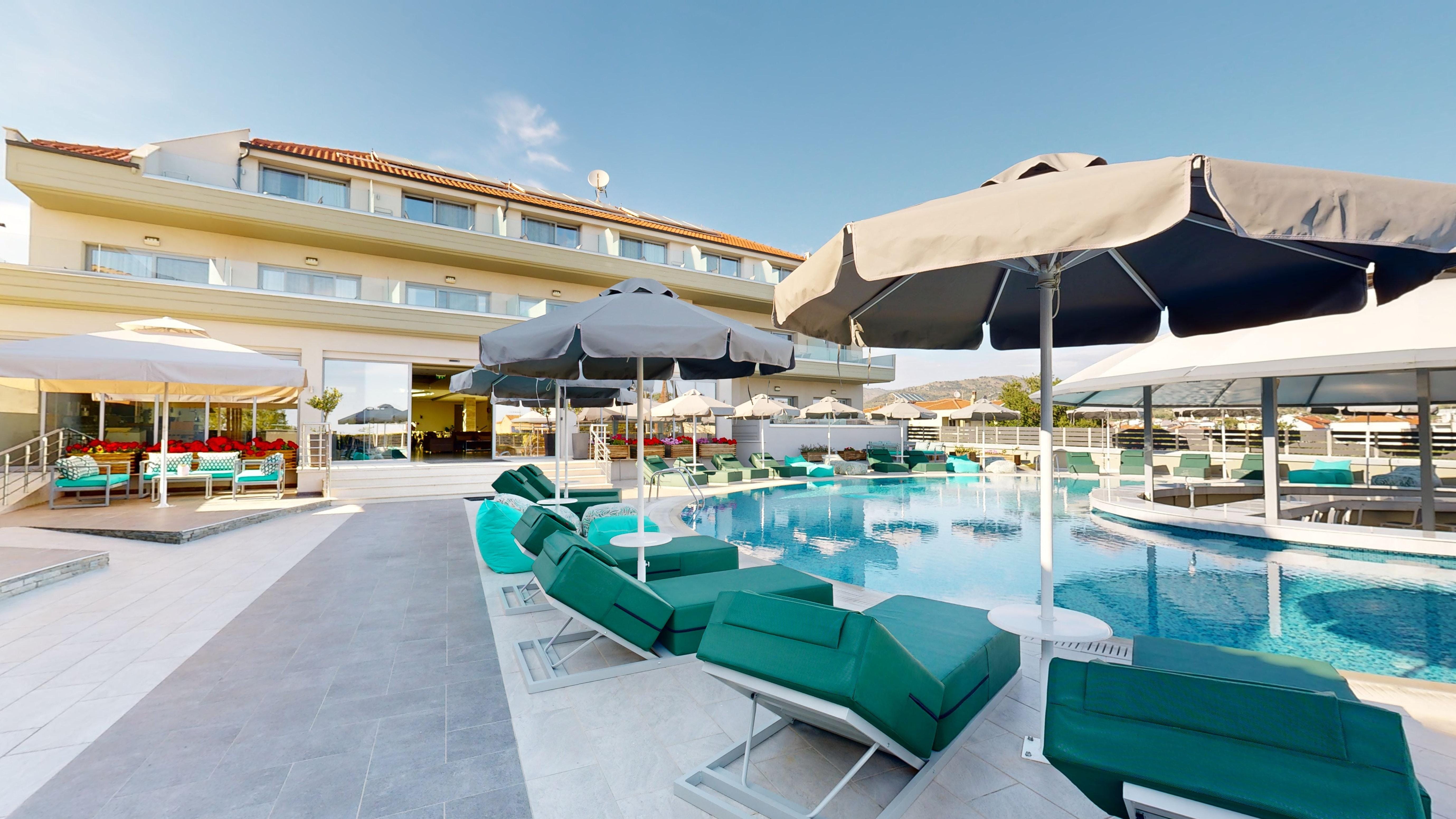 a pool with lounge chairs and umbrellas by it