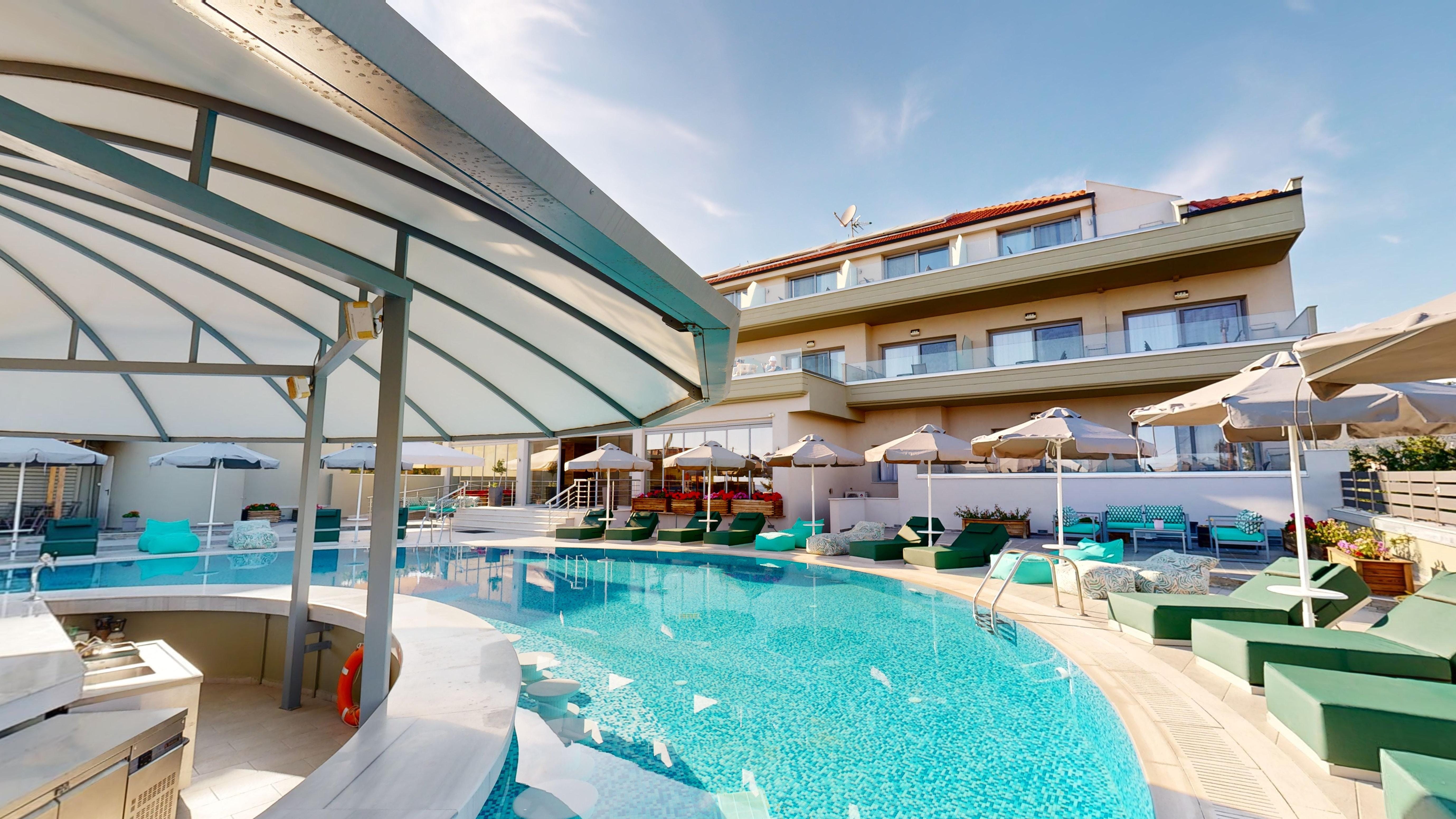a pool with lounge chairs and umbrellas next to a building
