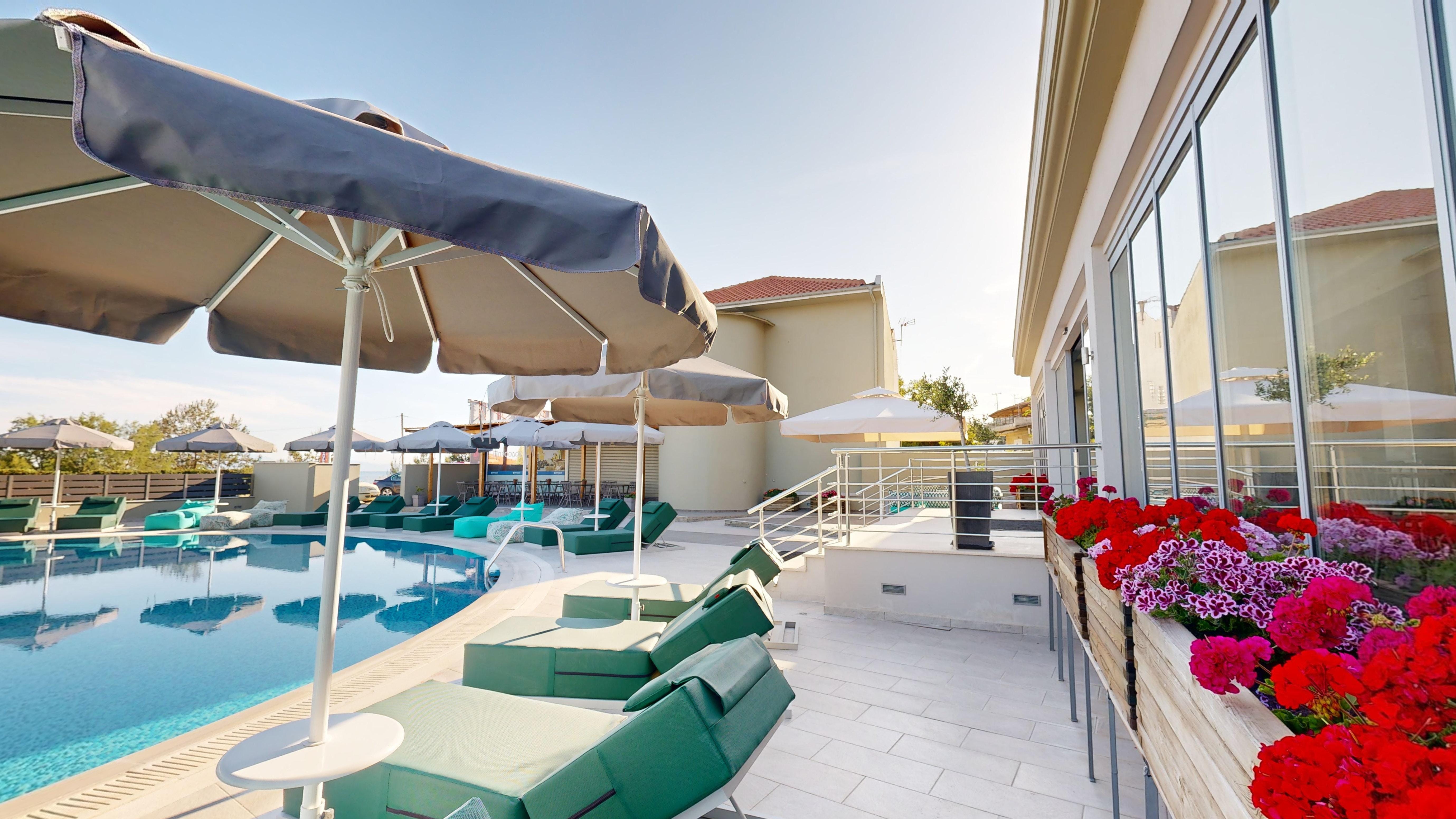 a pool with lounge chairs and umbrellas by it