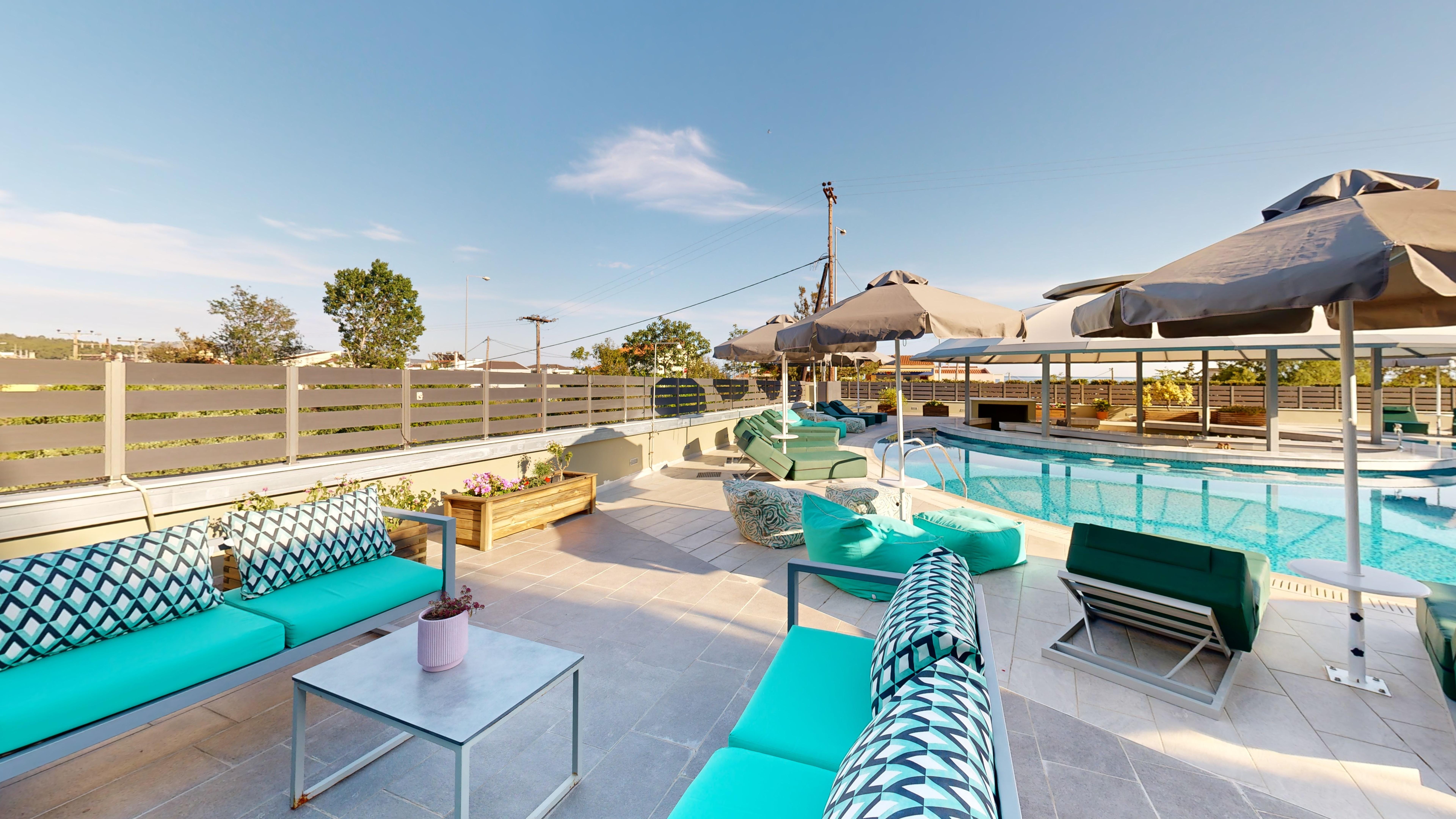 a pool with lounge chairs and umbrellas on a sunny day