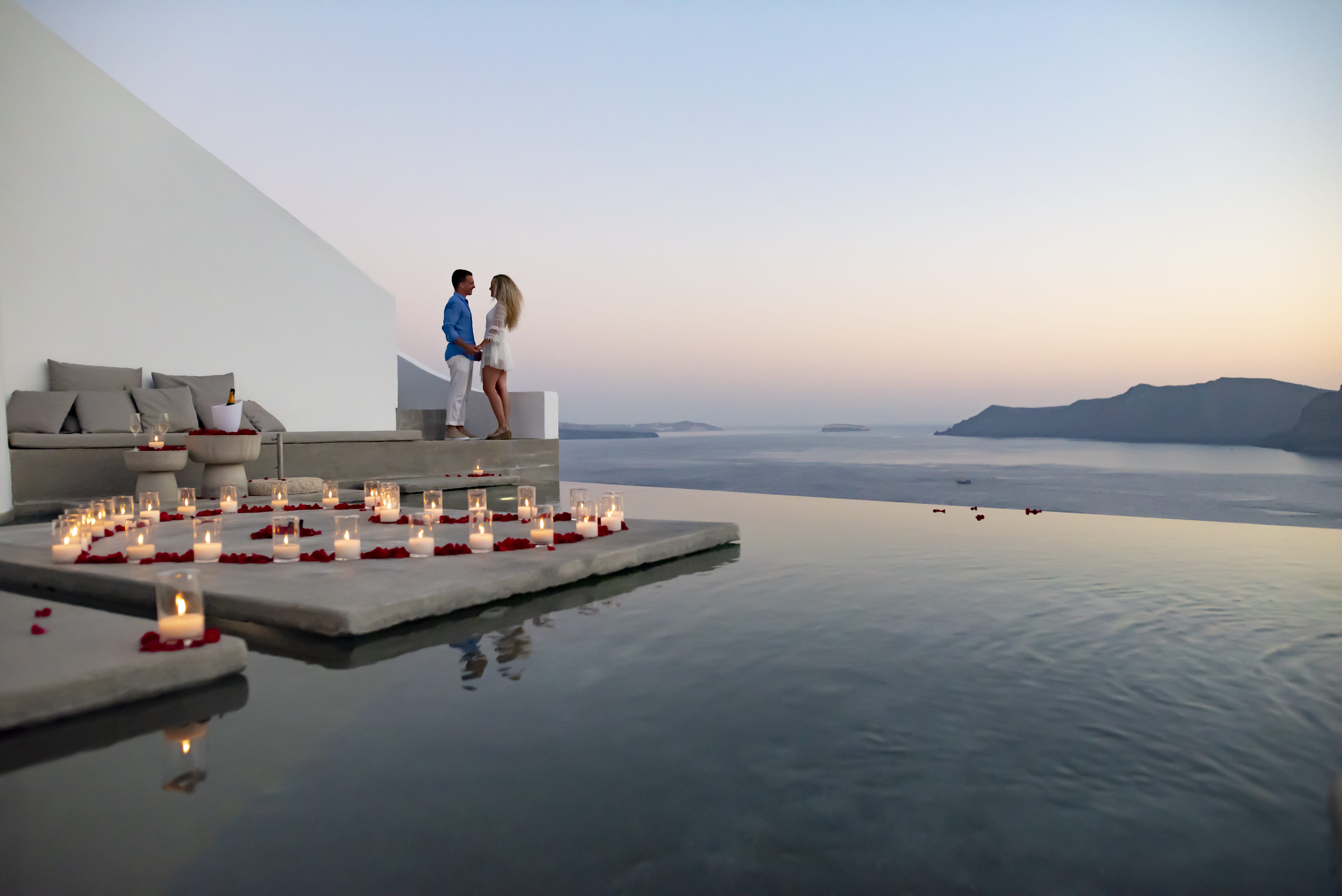 a man and woman standing on a building on a beach