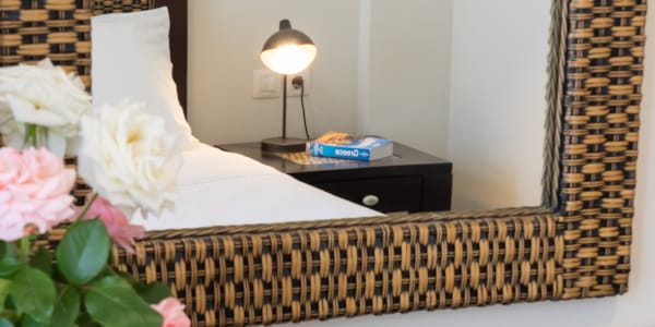 a bed with a white pillow and a lamp on the side