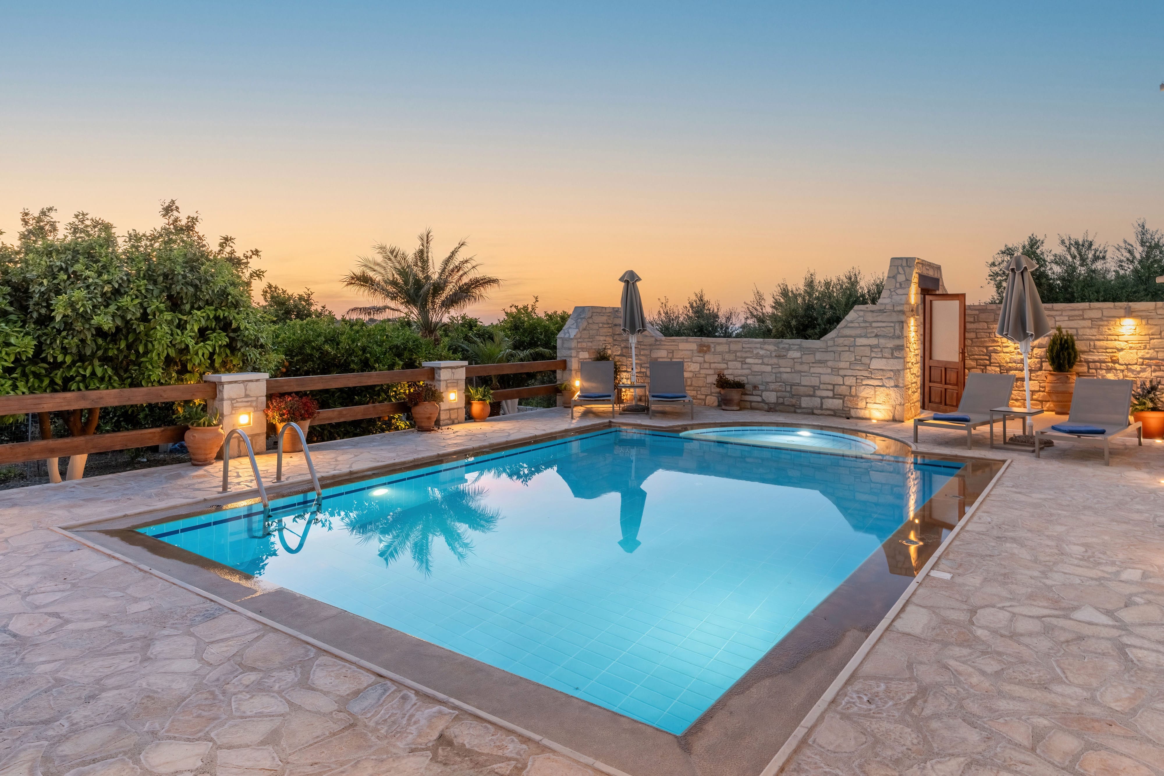 a pool with a stone wall and trees in the background
