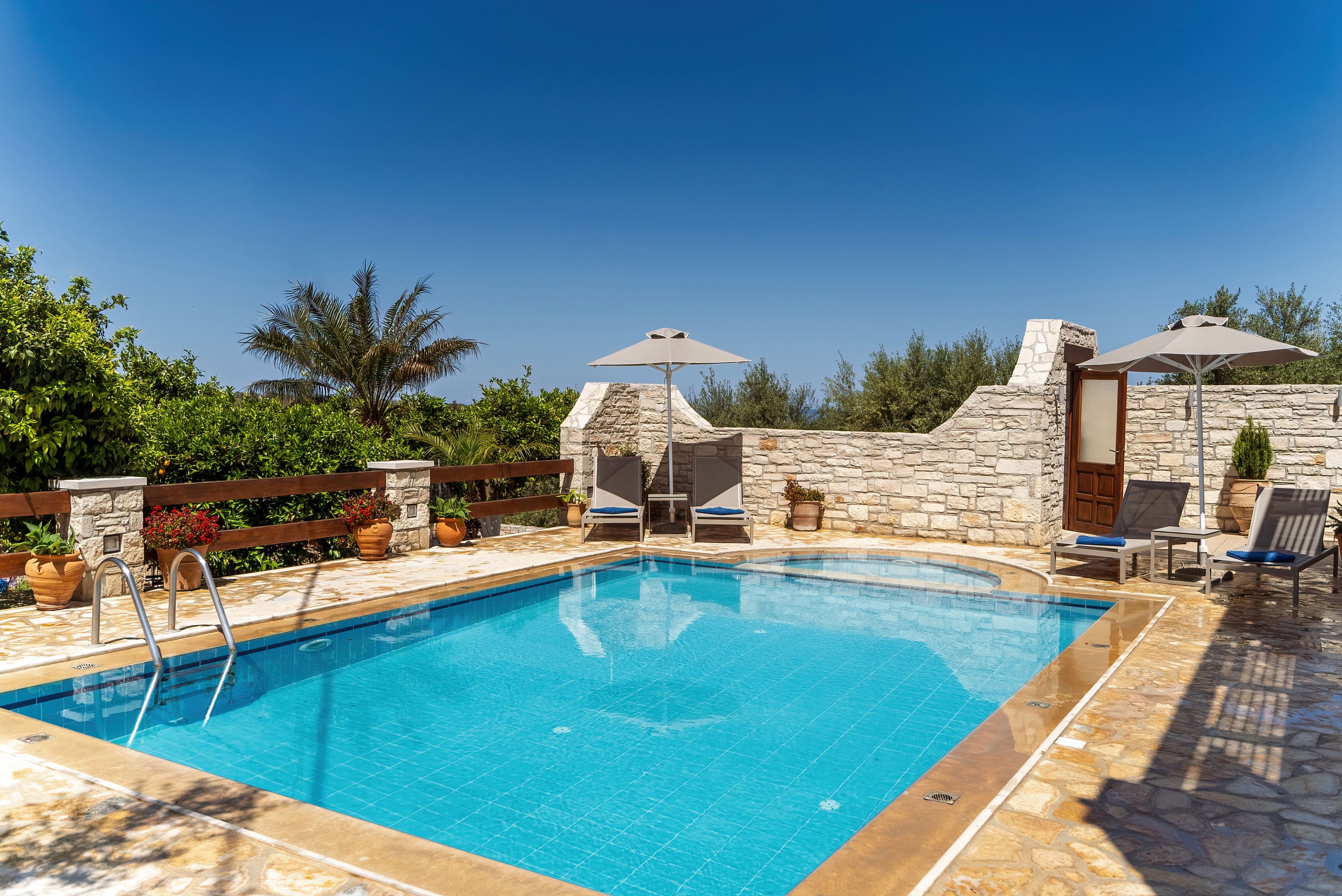 a swimming pool with a white tent and trees in the background