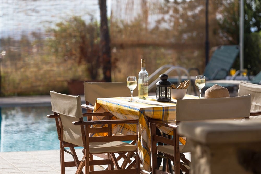 a table with glasses and bottles on it by a body of water
