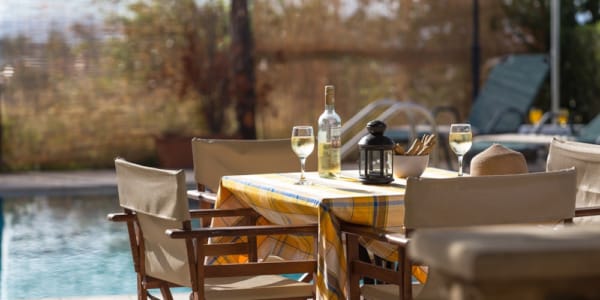 a table with glasses and bottles on it by a body of water