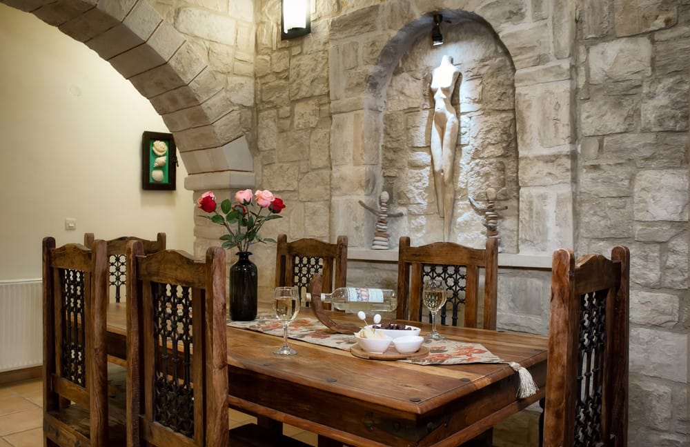a dining table with a vase of flowers on it