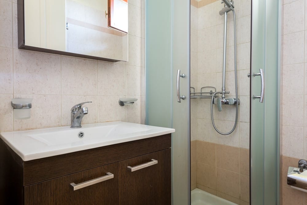 a bathroom with a shower unit and a sink