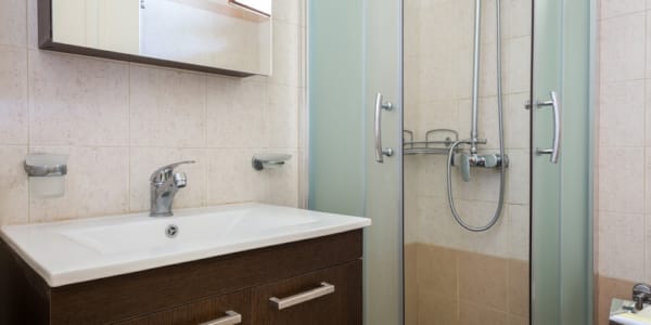 a bathroom with a shower unit and a sink