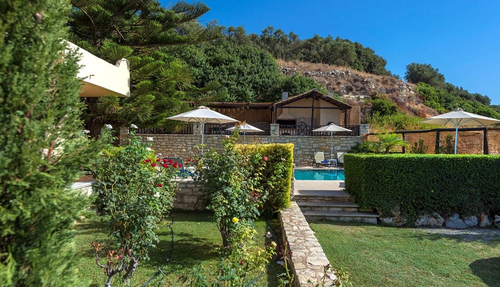 a house with a pool and bushes