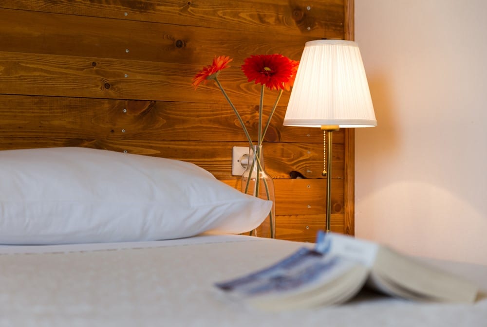 a flower is in a vase on a bed