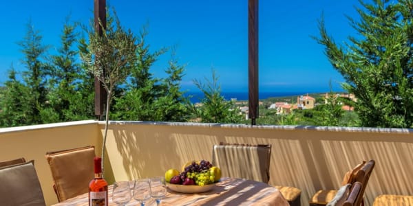 a table with a bowl of fruit and a bottle of wine on it