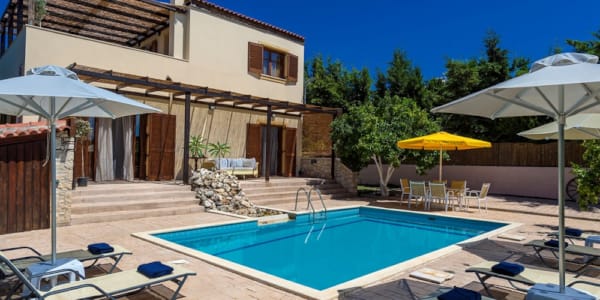 a pool with lounge chairs and umbrellas next to it