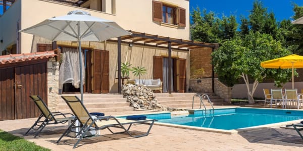 a swimming pool with chairs and umbrellas next to it