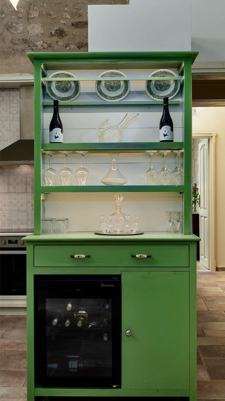 a green cabinet with glasses and plates