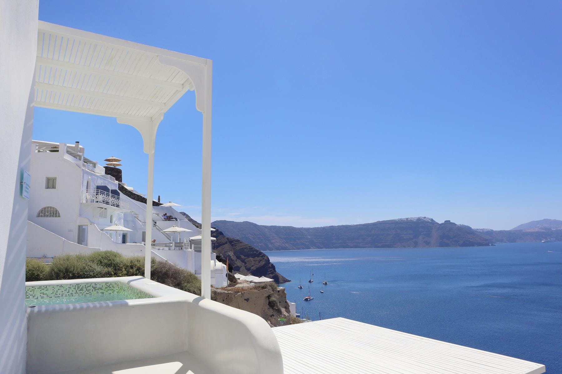 a white building on a cliff above water