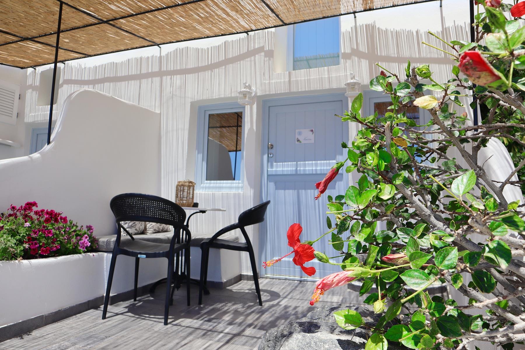 a patio with a table chairs and plants