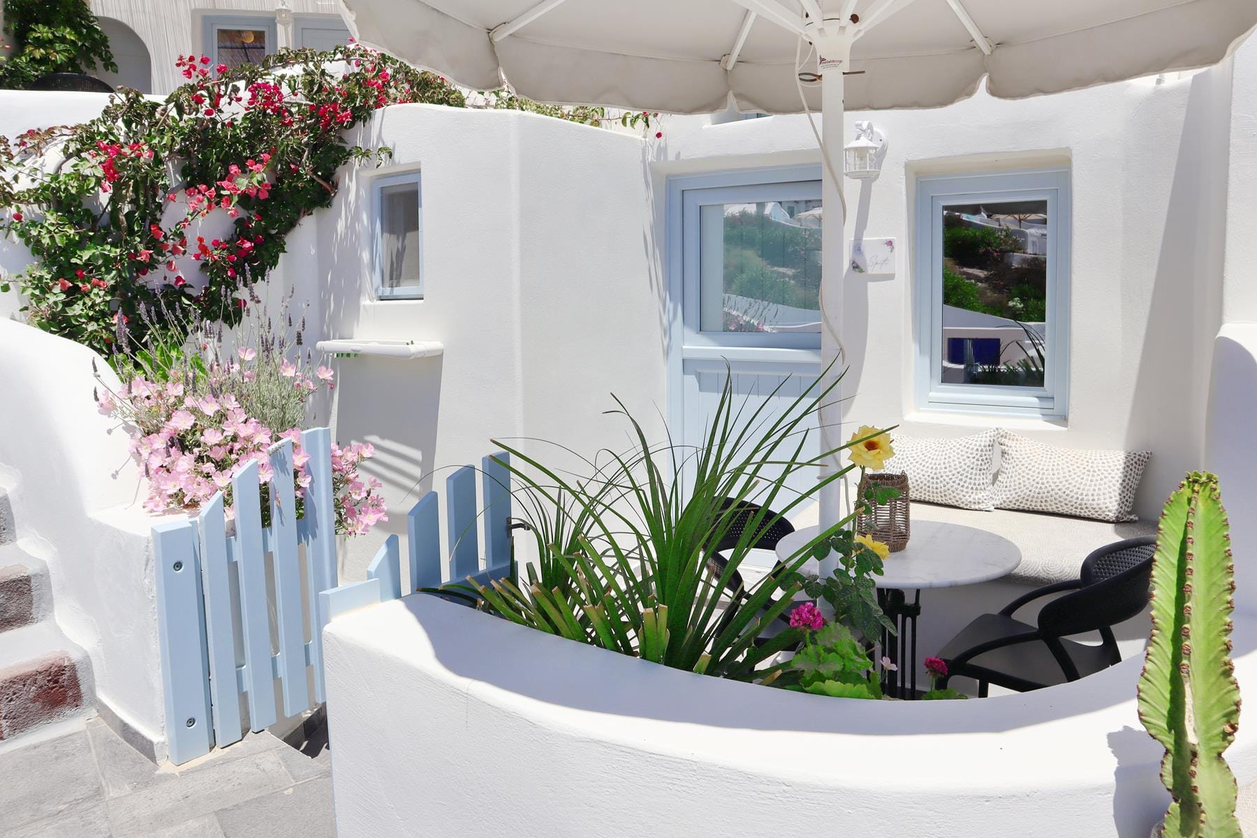 a white house with a white table and plants