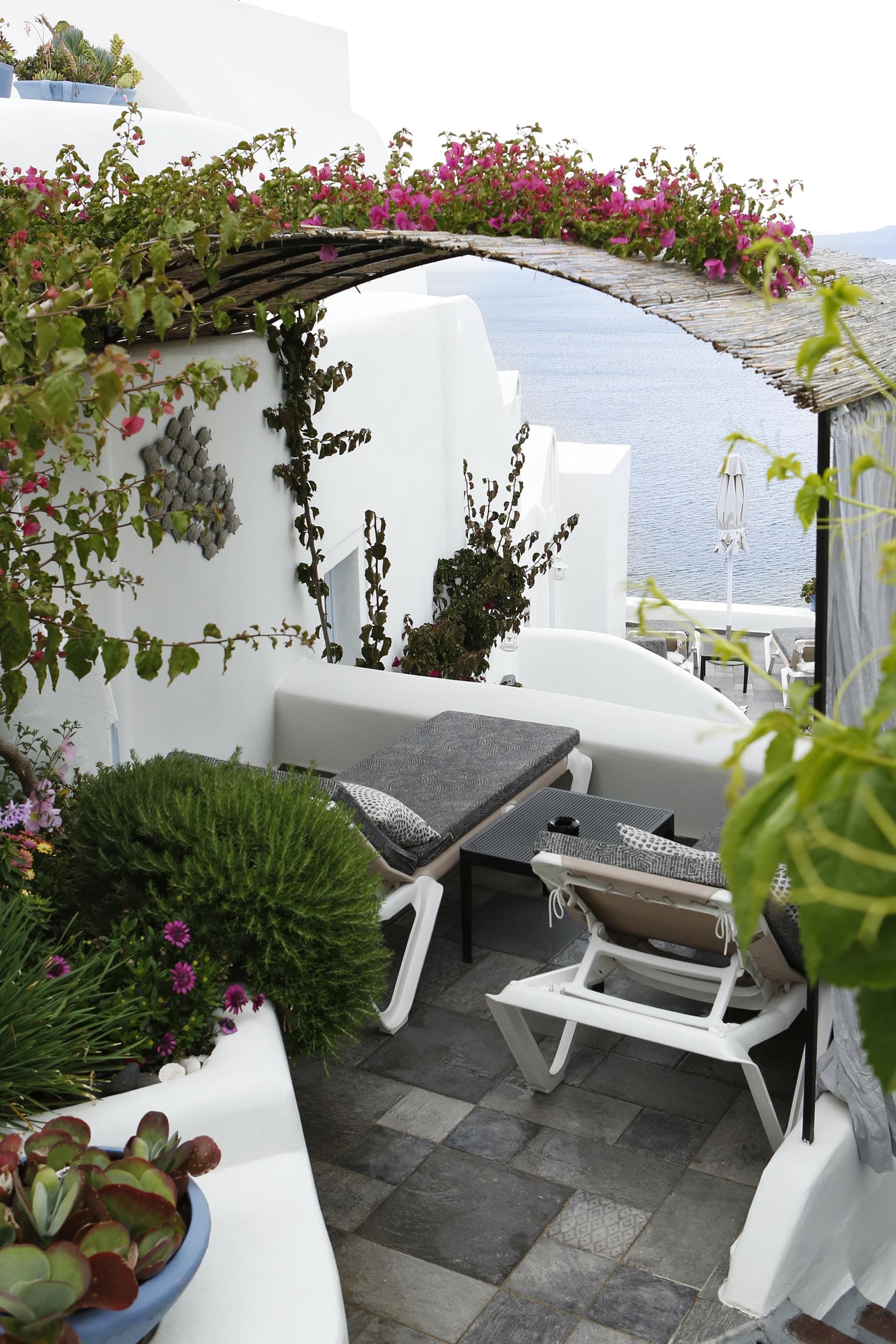 a patio with chairs and plants
