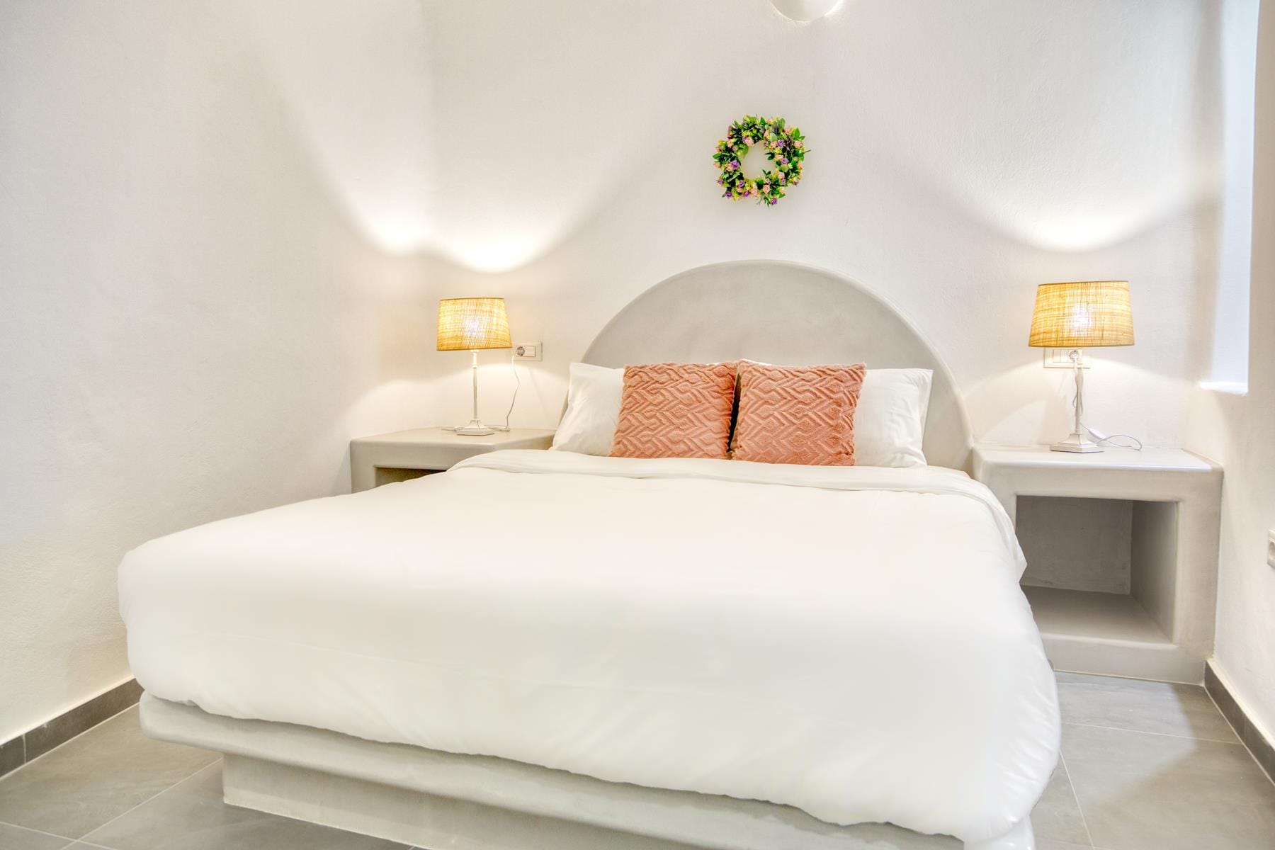 a bed with pillows and lamps