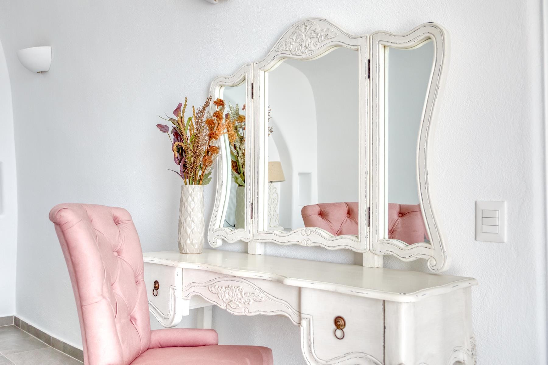 a pink chair in front of a mirror