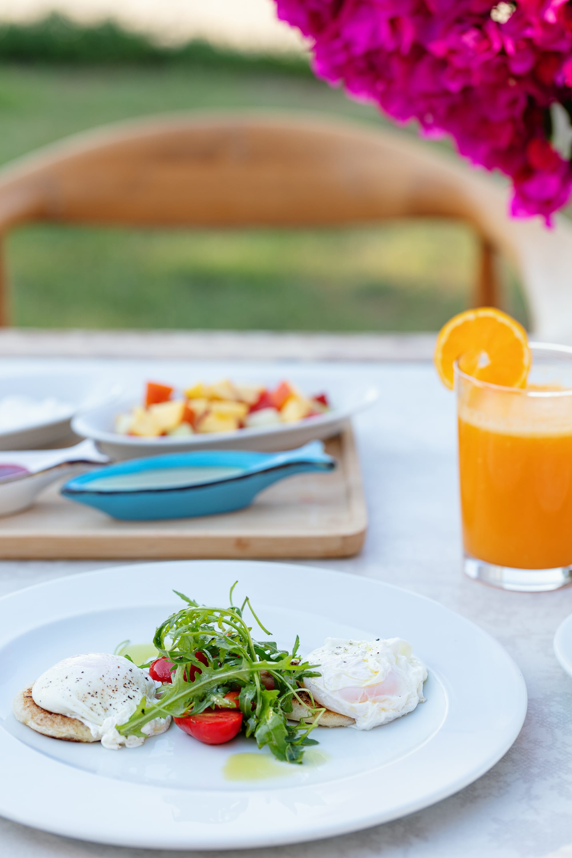 a table with plates of food and a glass of juice