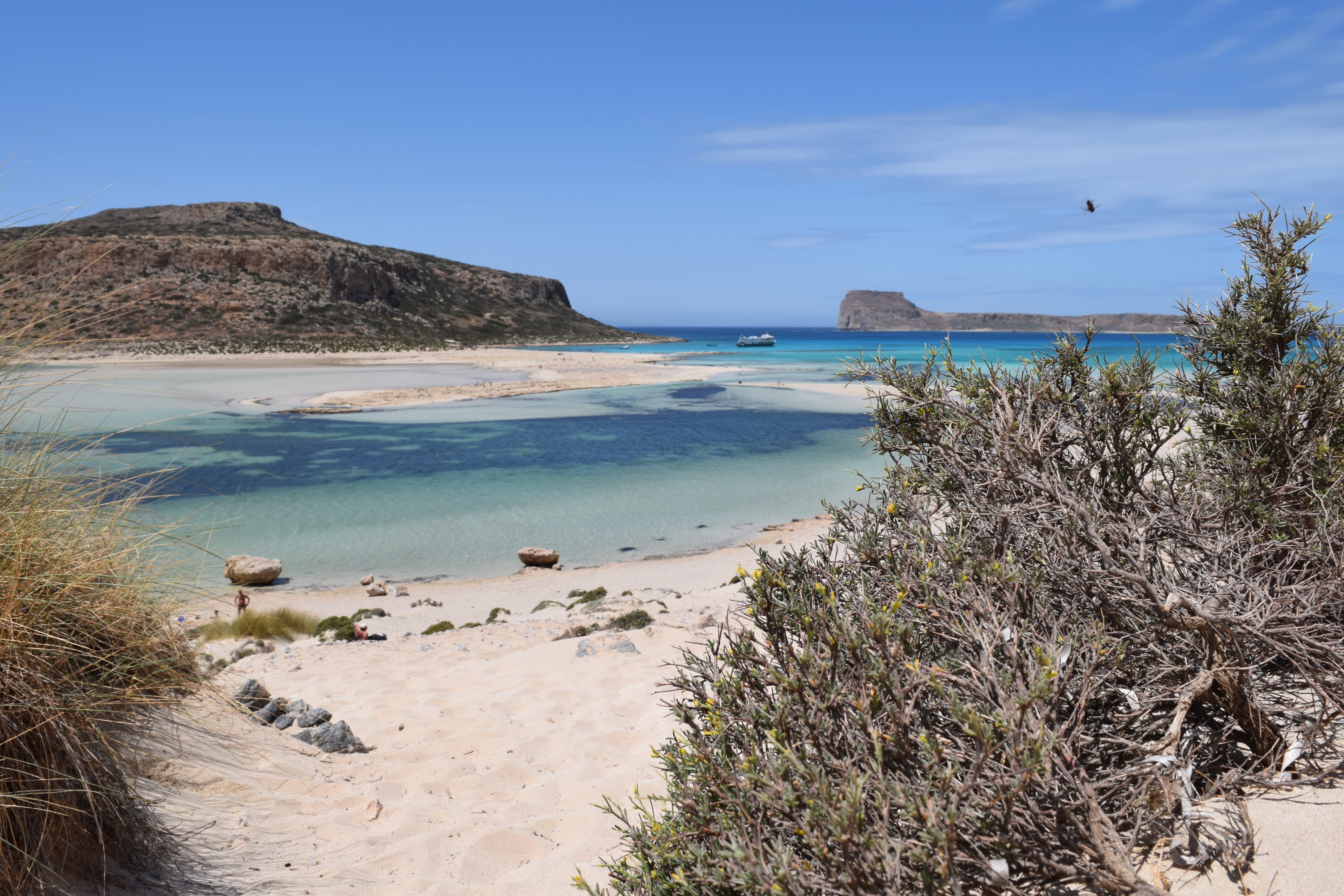 a sandy beach with blue water