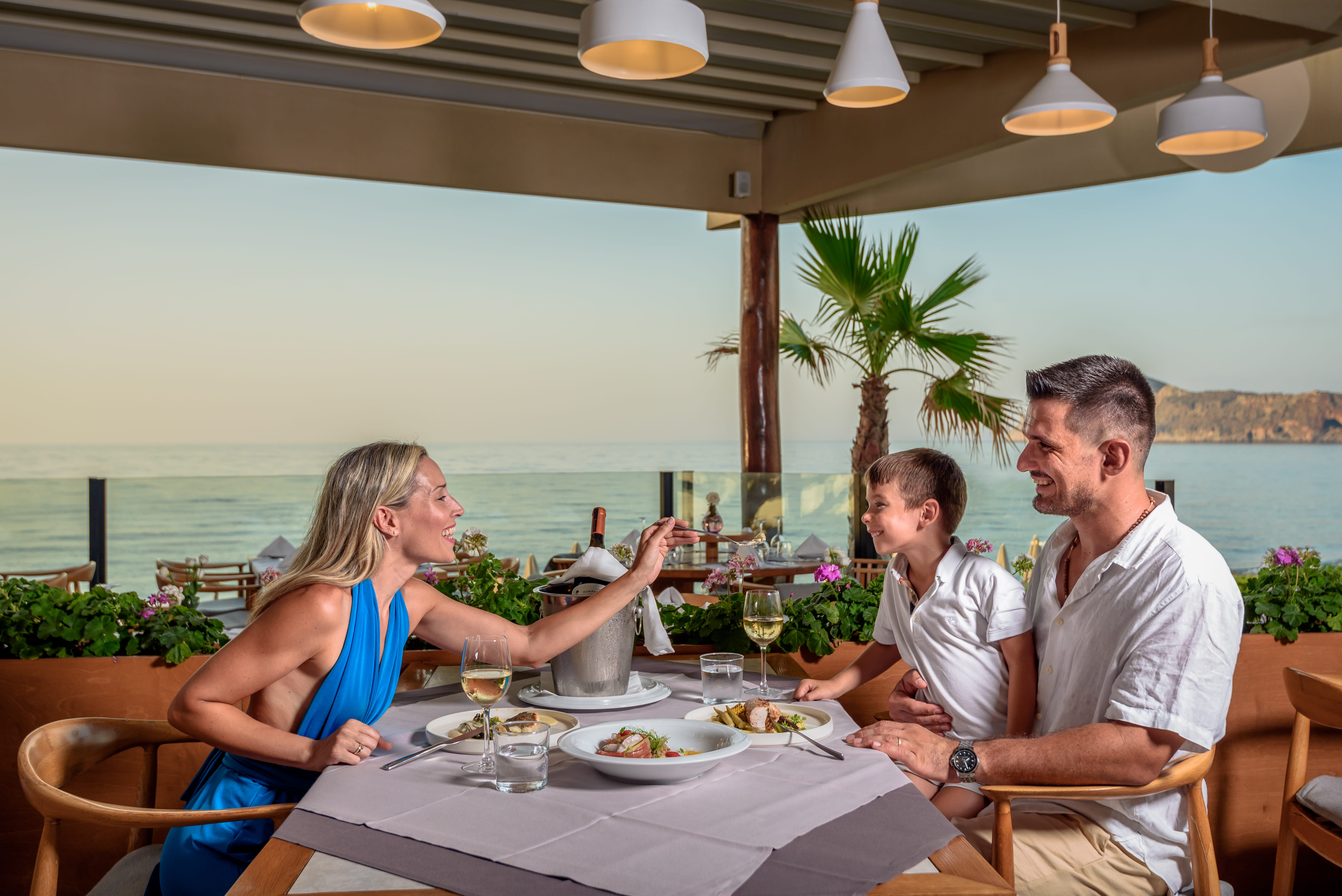 a group of people sitting at a table with food and drinks