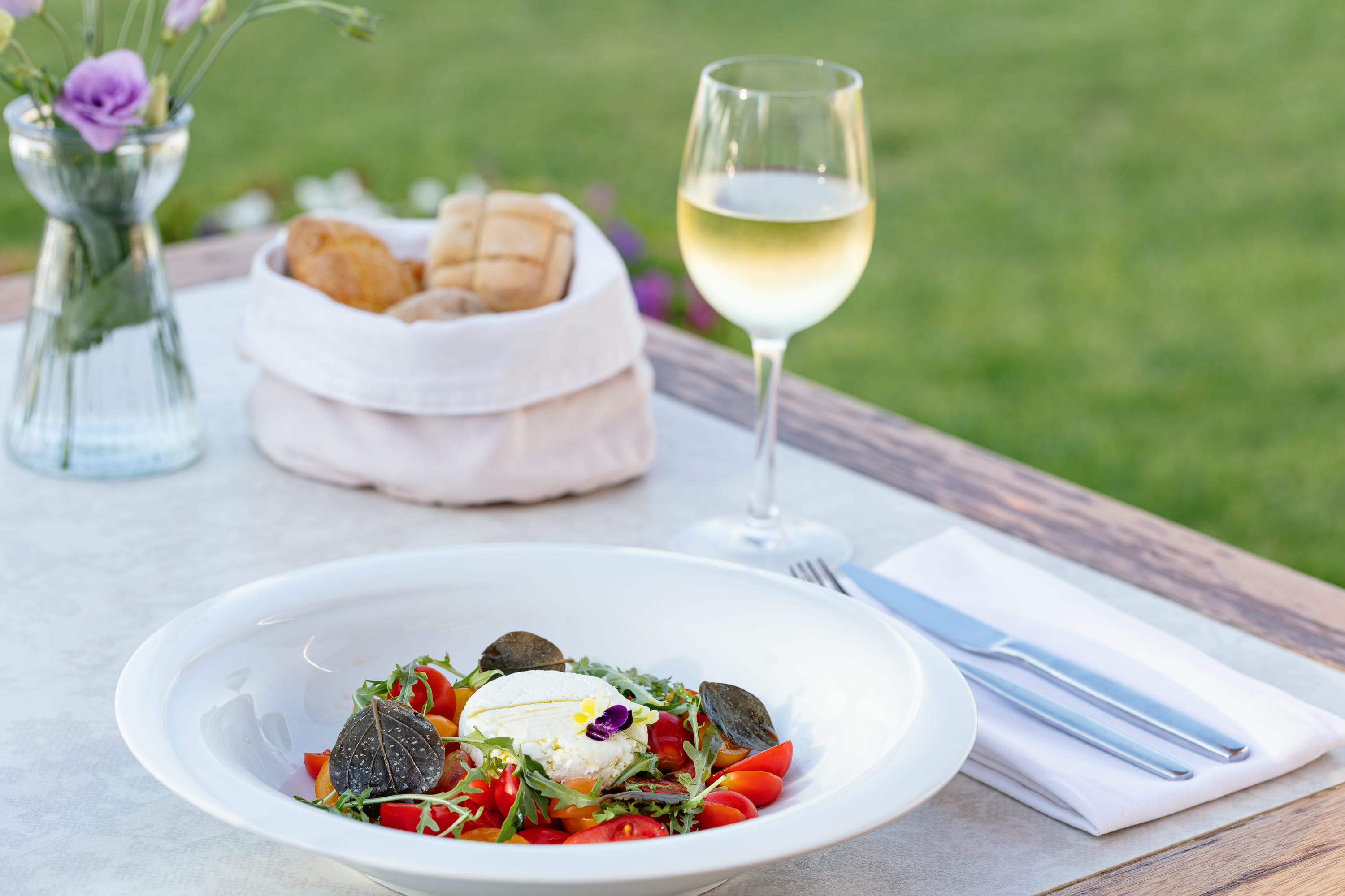 a plate of food and a glass of wine on a table