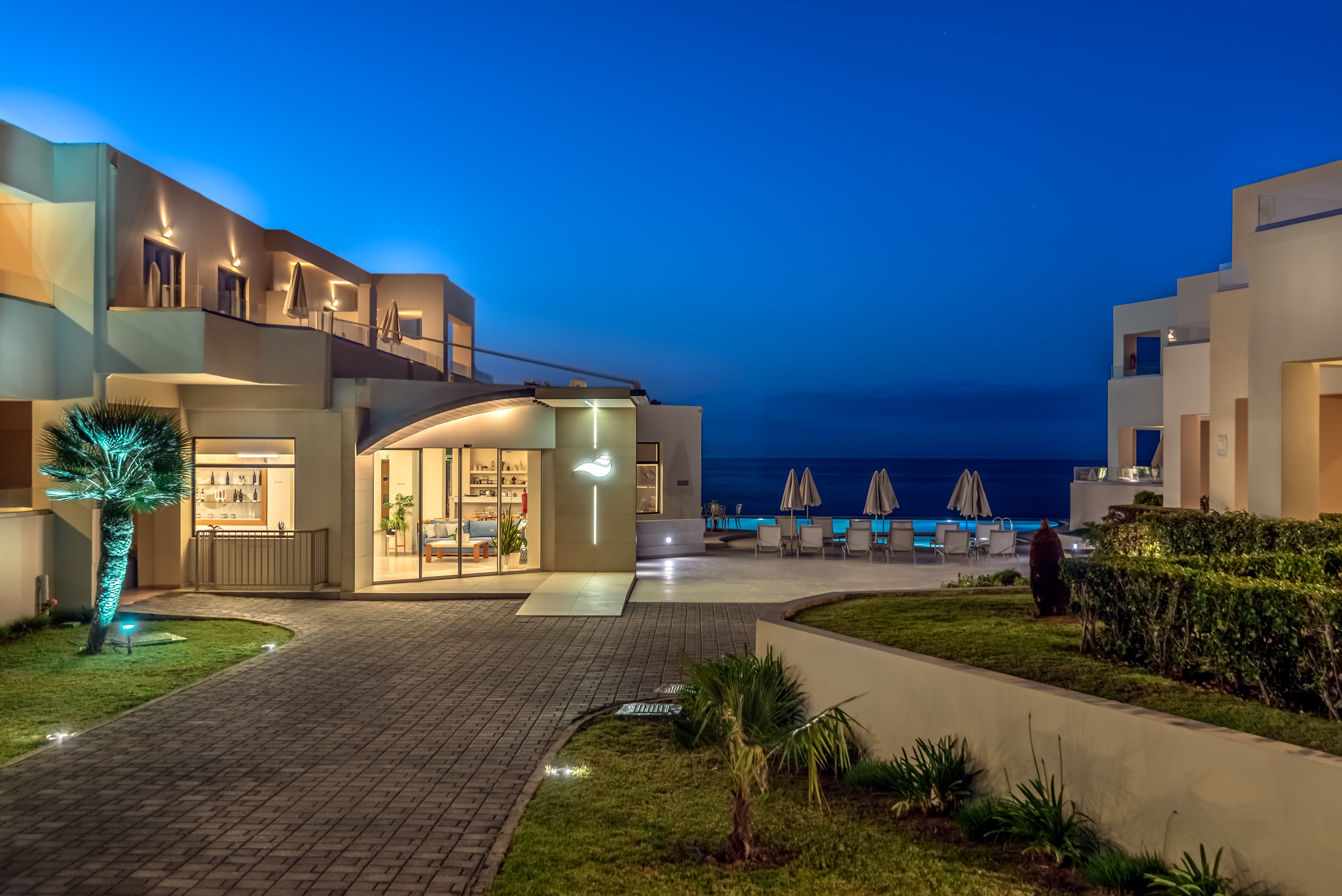 a building with a walkway and a body of water in the background
