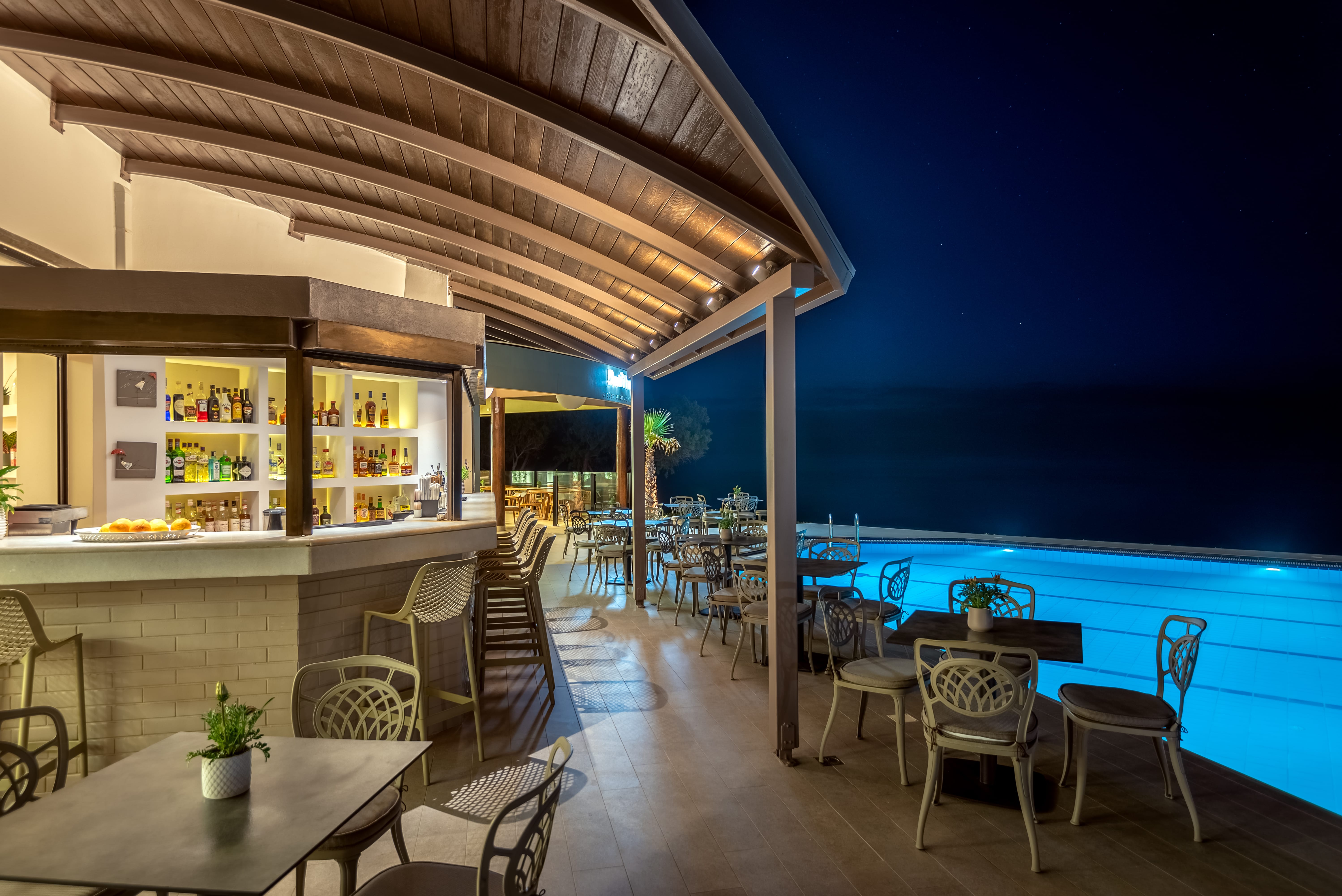 a bar with a pool and chairs