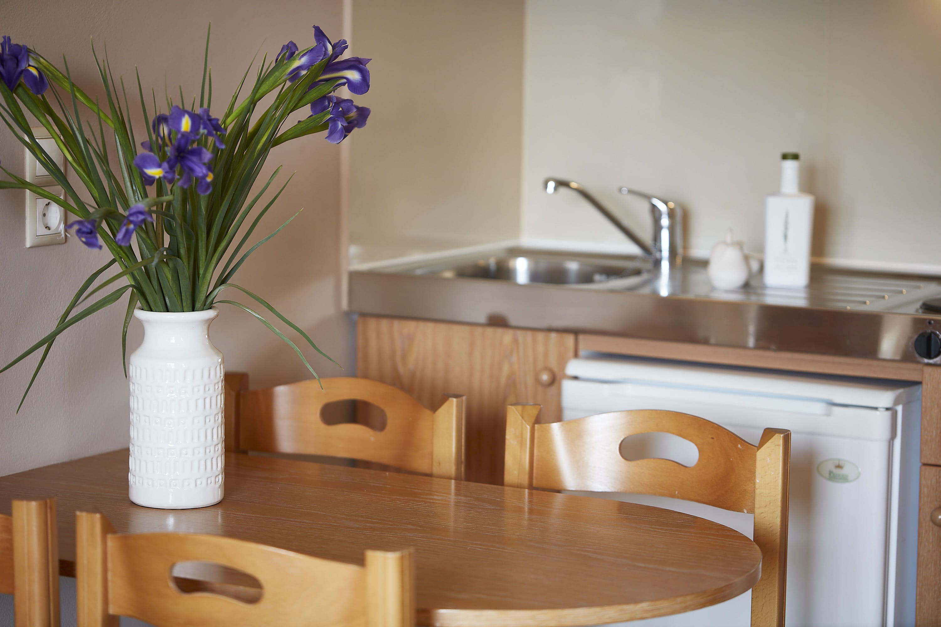 a vase with purple flowers on a table