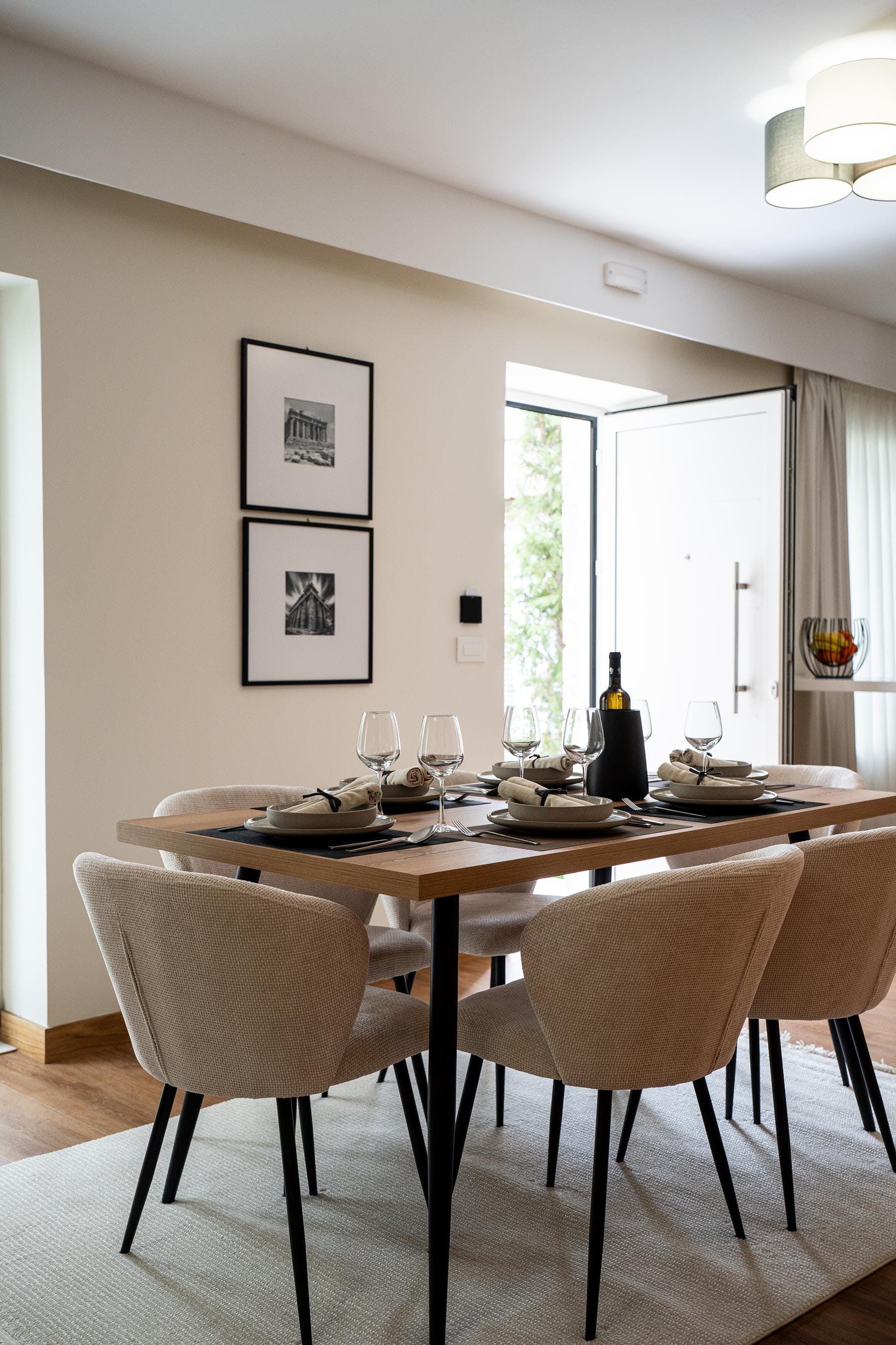 a dining table with chairs and a wine bottle on it