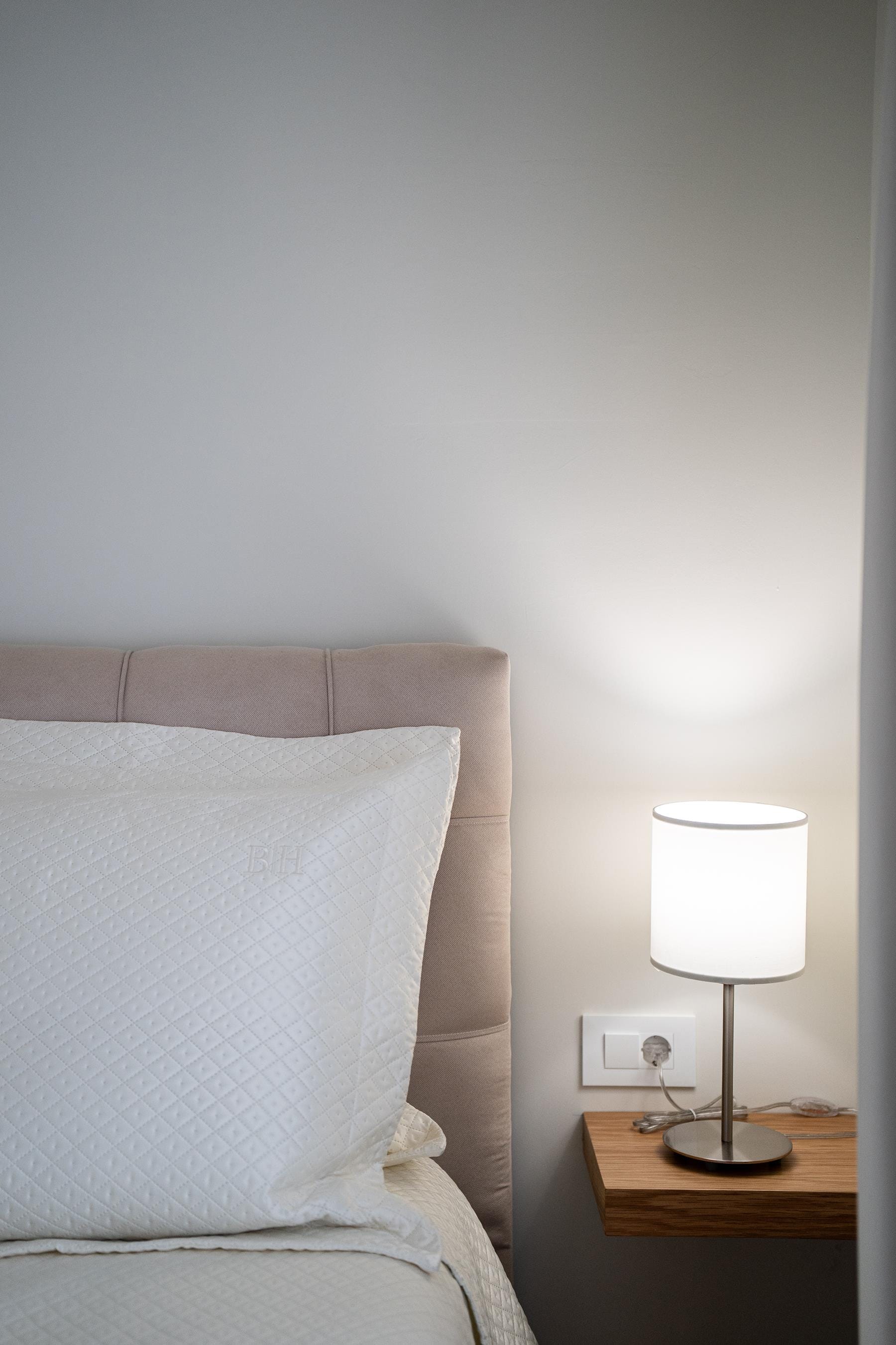 a lamp next to a bed