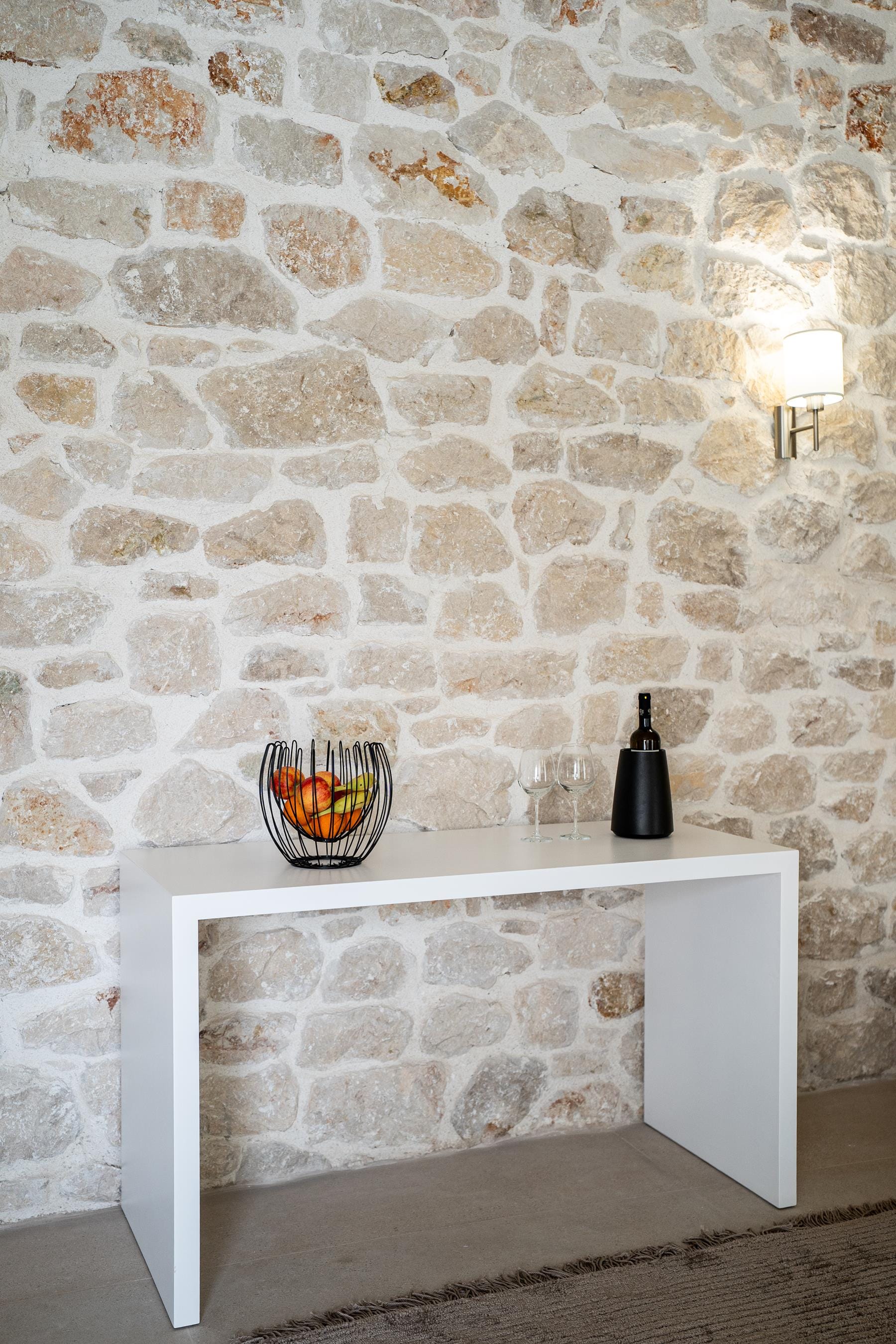 a fireplace with a bowl of fruit and a bottle of wine