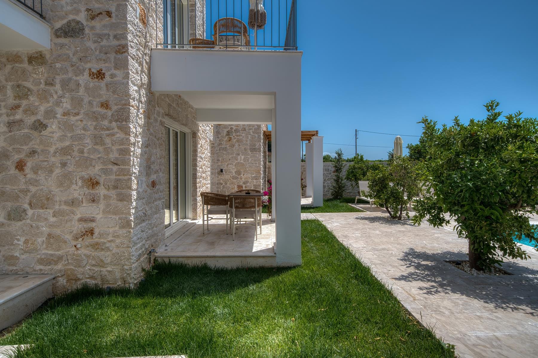 a stone building with a patio and a table and chairs