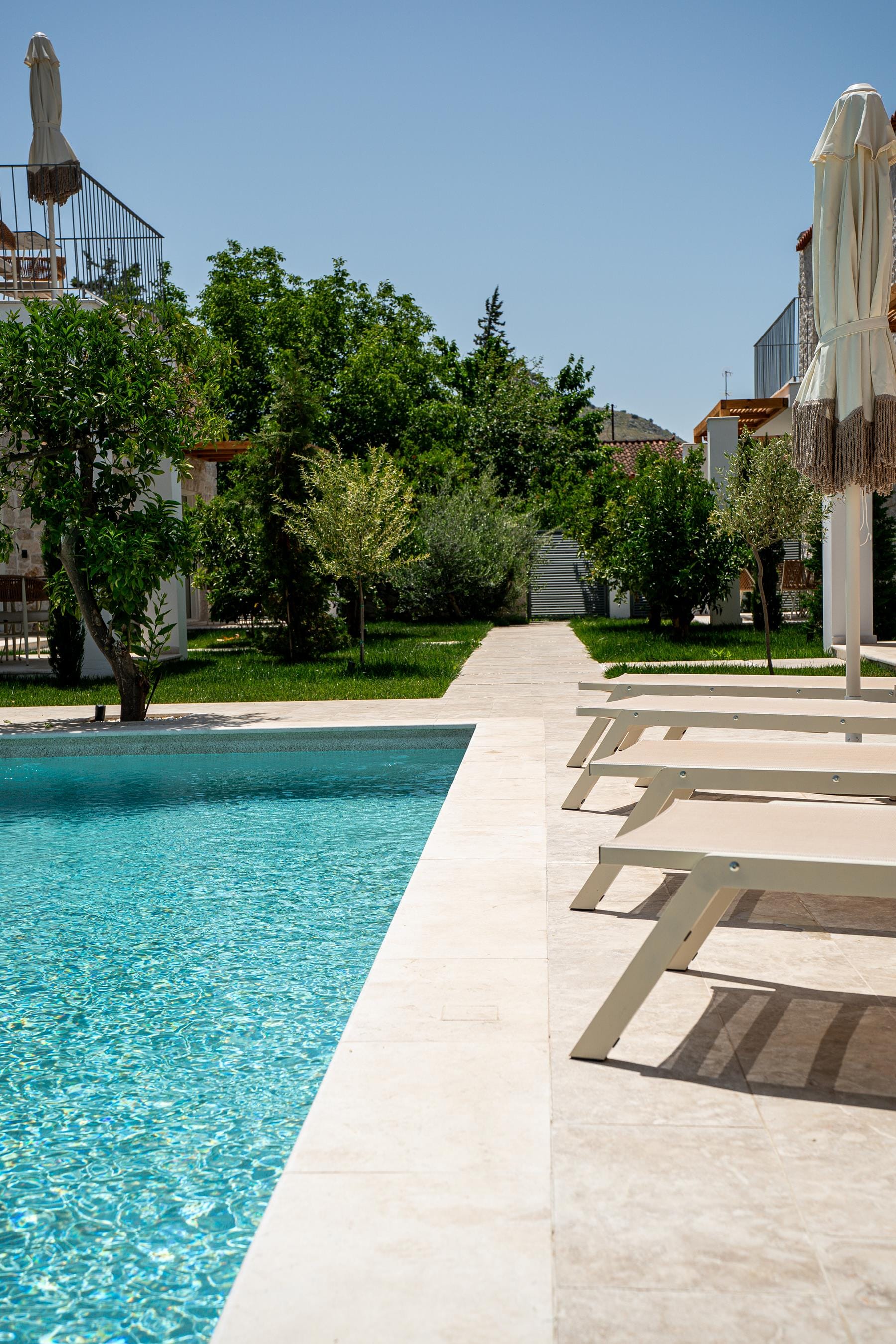 a pool with trees and buildings in the background