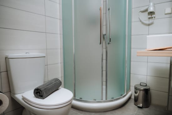 a bathroom with a toilet and a shower unit