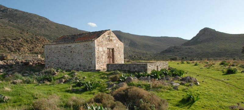 a stone building in a grassy field