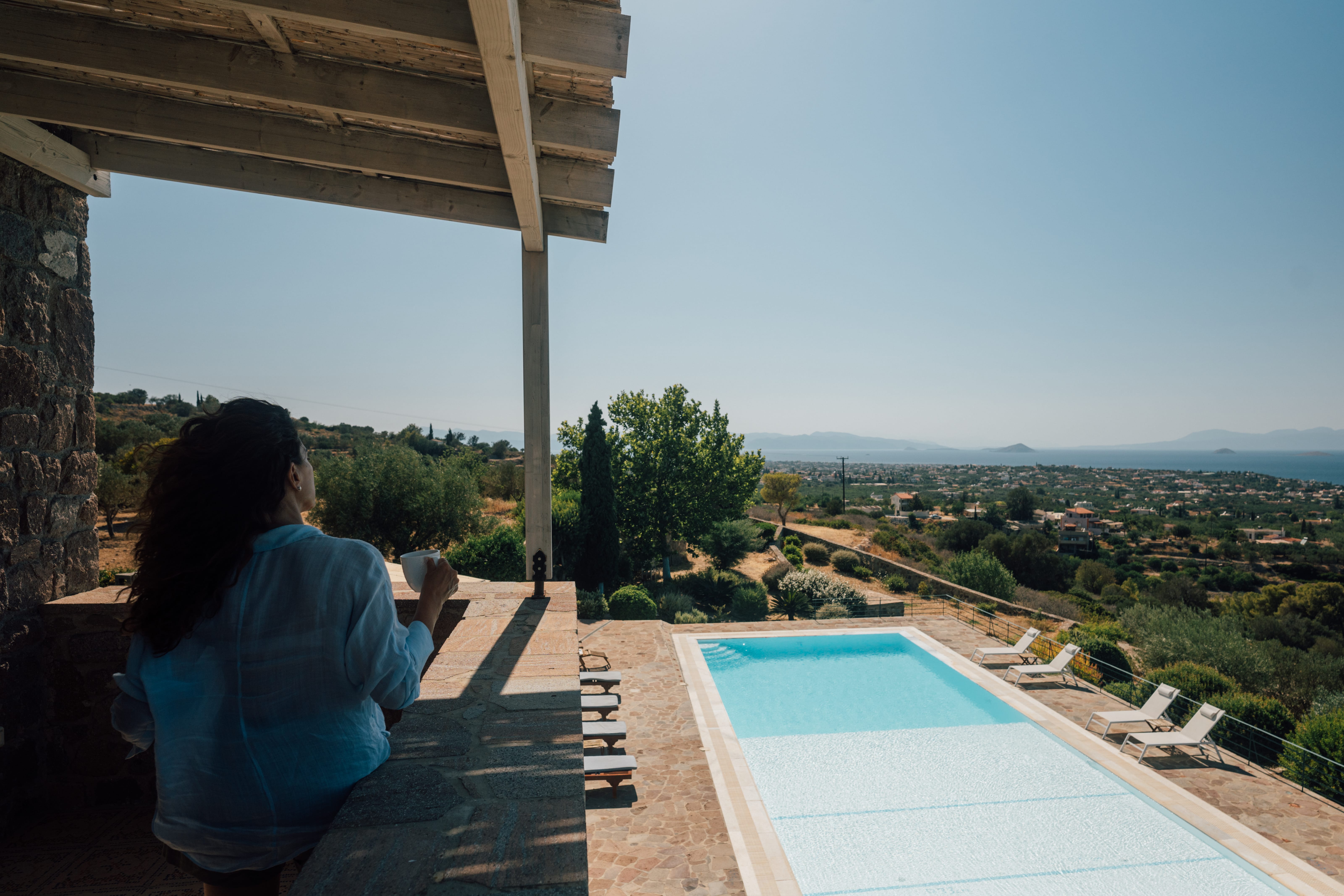 a person sitting on a balcony overlooking a pool