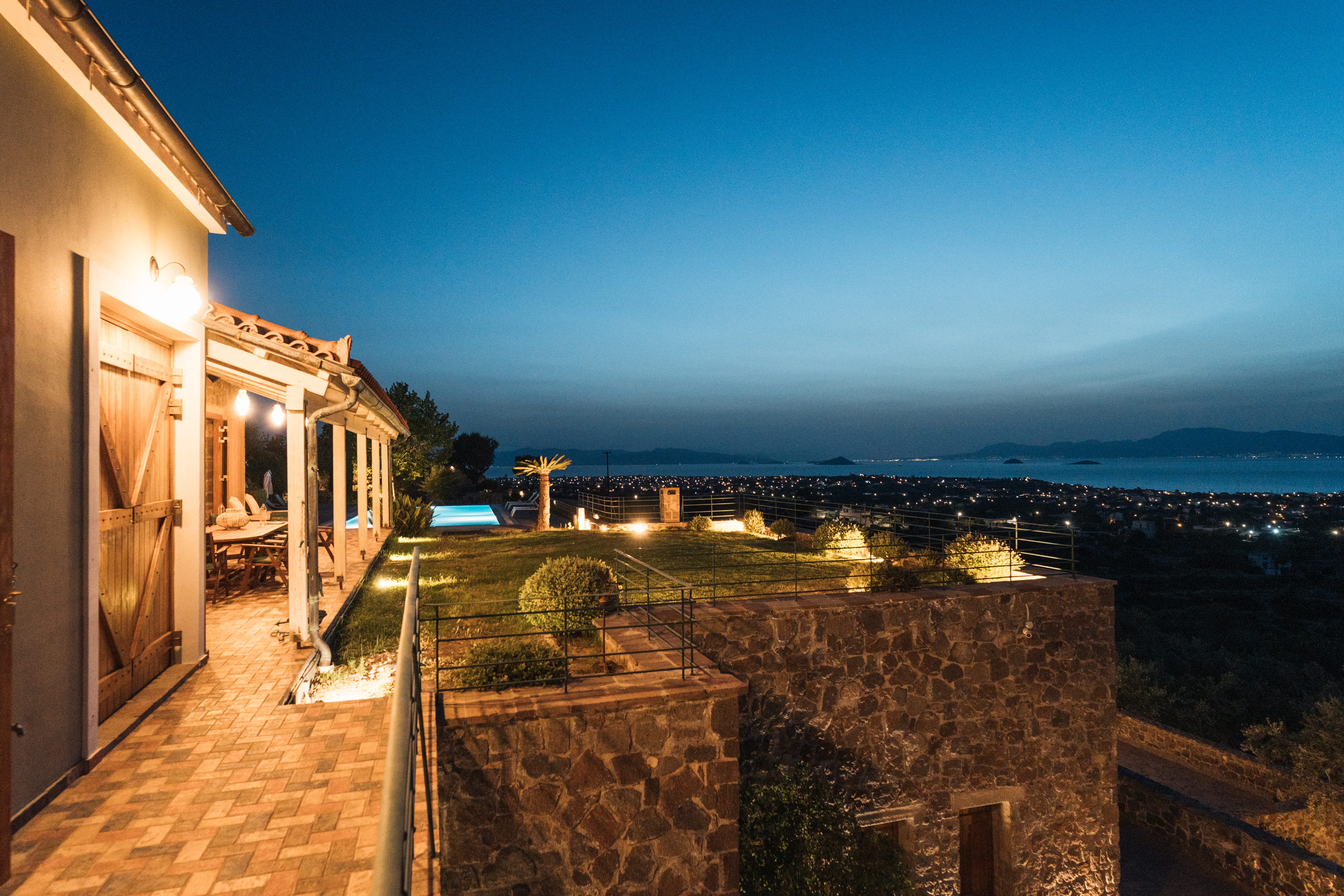 a building with a stone wall and a body of water in the background