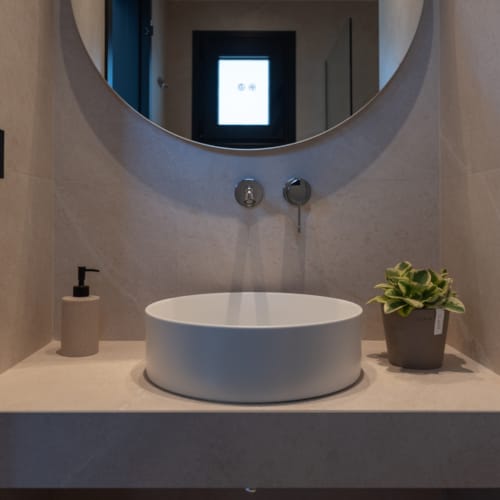 a bathroom with a round mirror