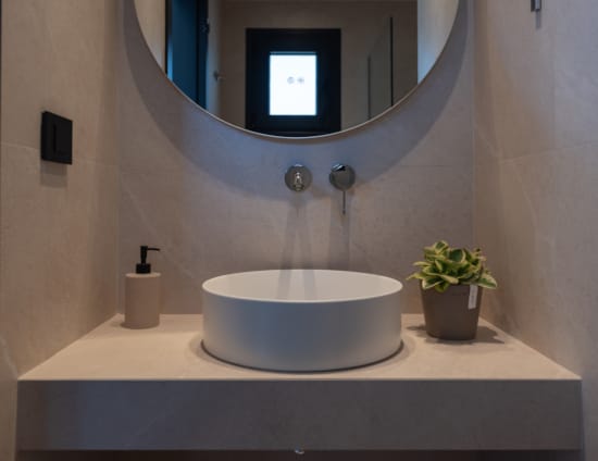 a bathroom with a round mirror