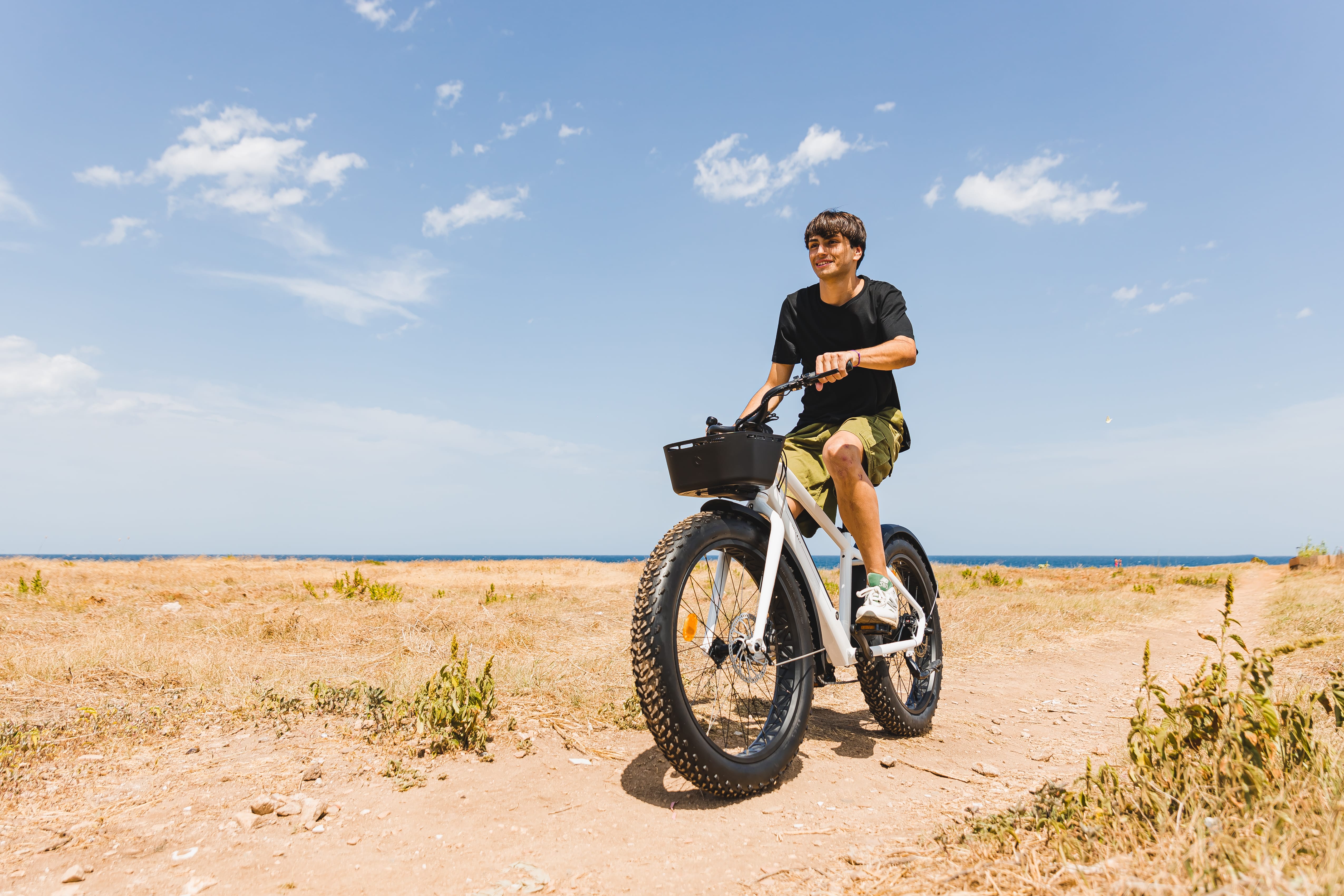 a man riding a bike on a sandy beach