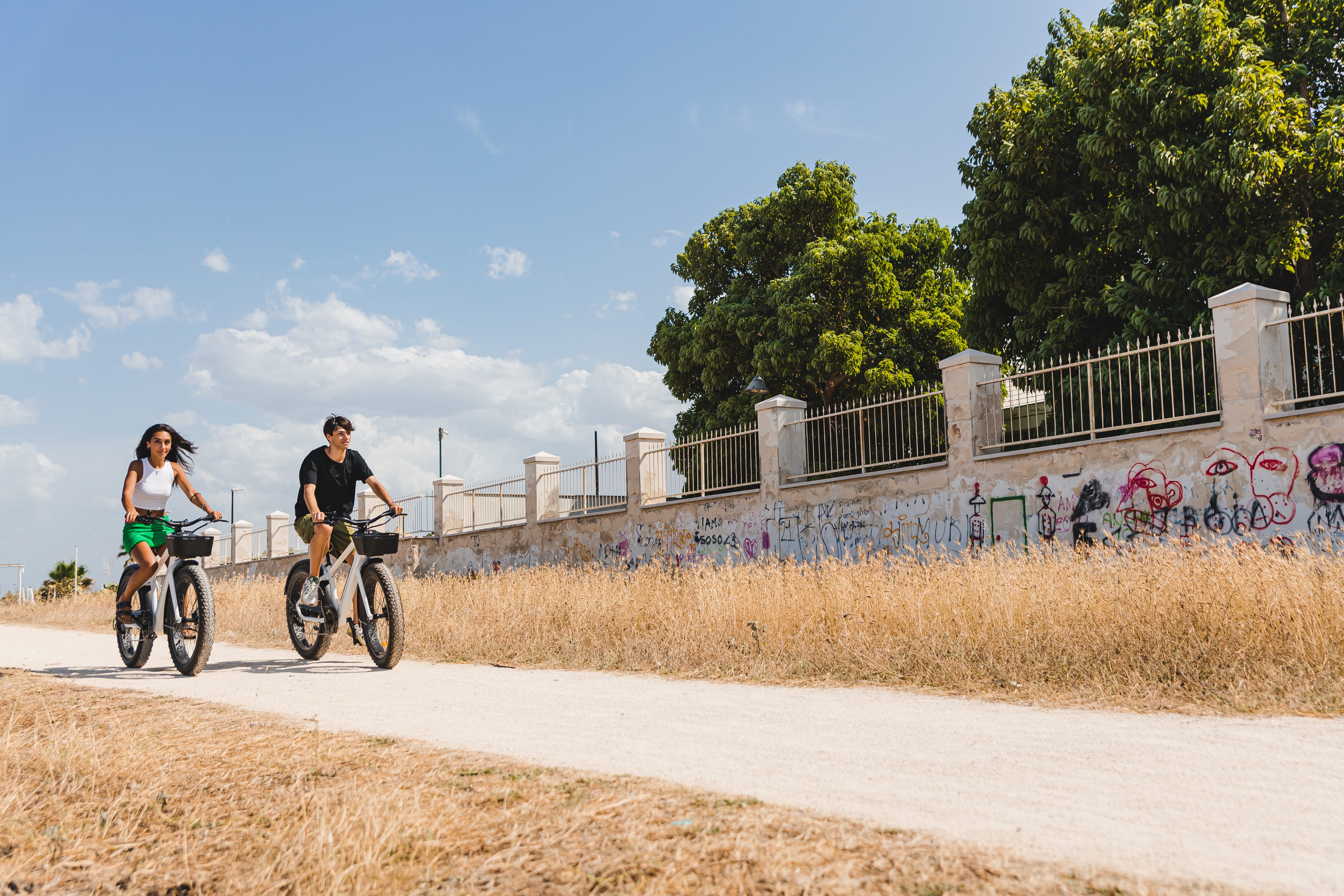 a man and a woman riding bikes on a dirt road